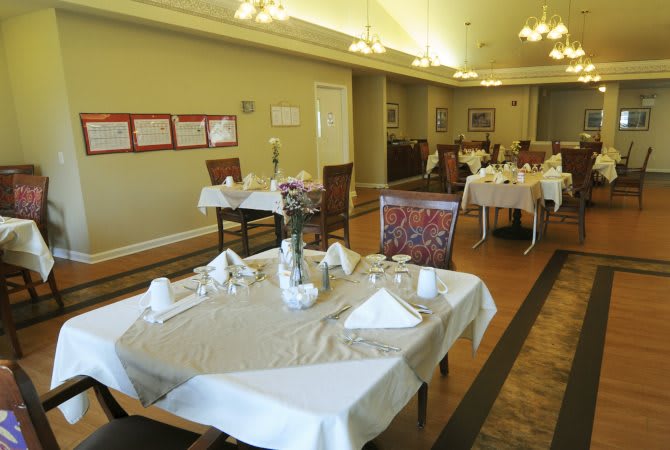 A well-set dining area in a restaurant with neatly arranged tables and chairs.