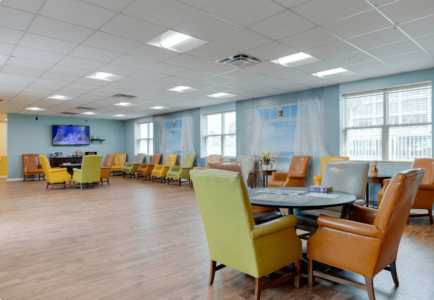 A bright and spacious waiting room with comfortable seating and a television.