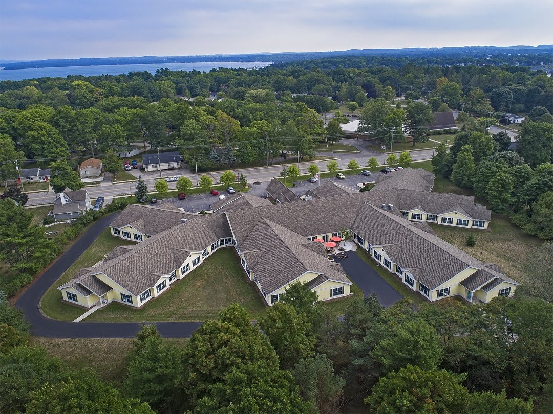 Aerial view of a large building complex surrounded by trees and roads.