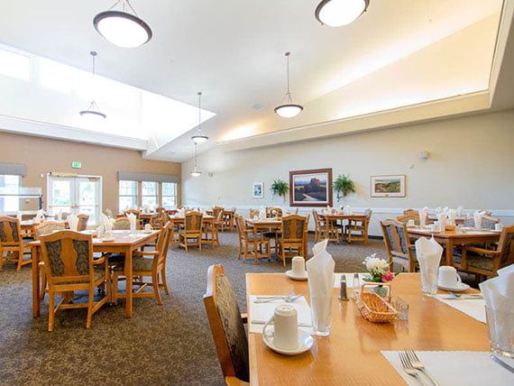 A spacious and well-lit dining area with neatly arranged tables and chairs.