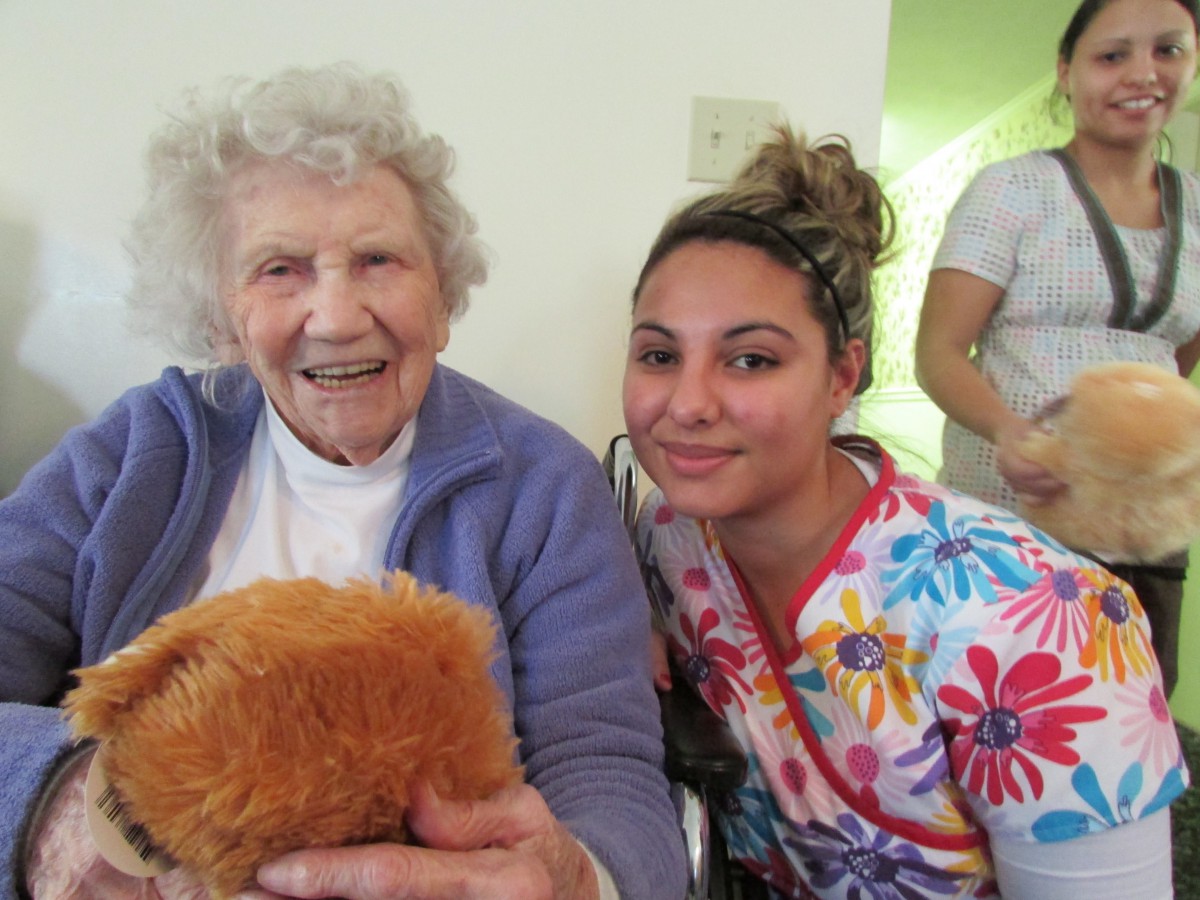 An elderly woman and a young caregiver share a joyful moment together.