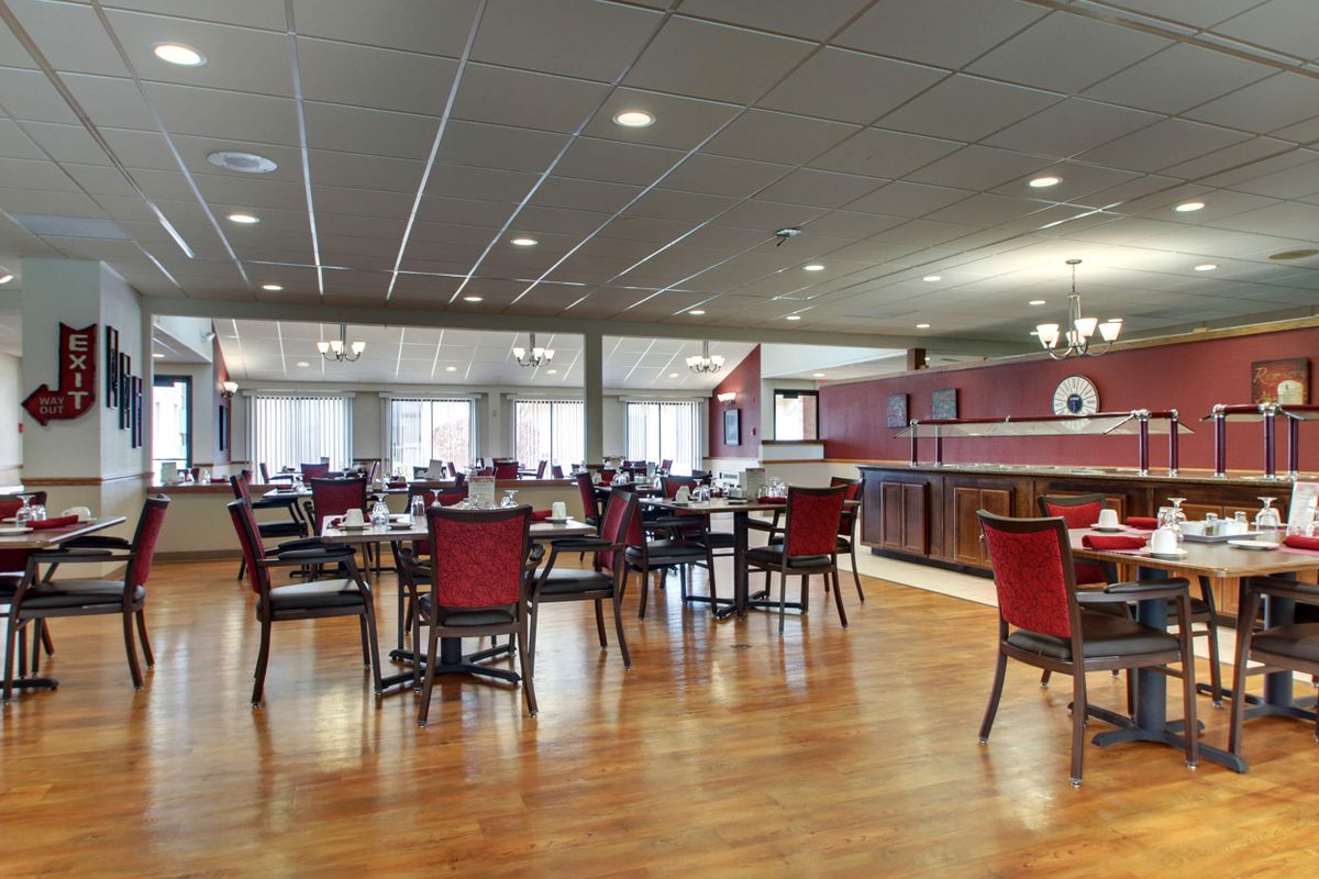 An empty restaurant dining area with neatly arranged tables and chairs.