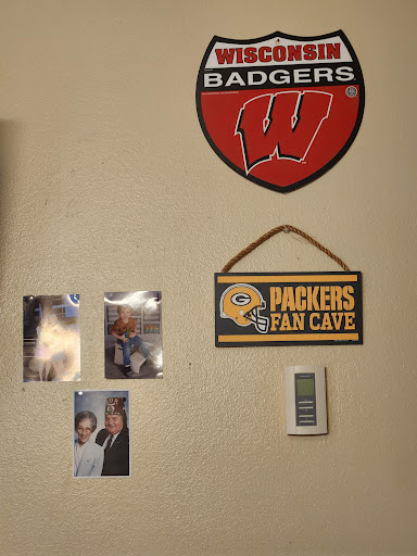 A sports-themed wall featuring Wisconsin Badgers and Green Bay Packers memorabilia.