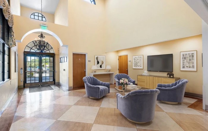 A modern lobby with comfortable seating, a television, and elegant decor.