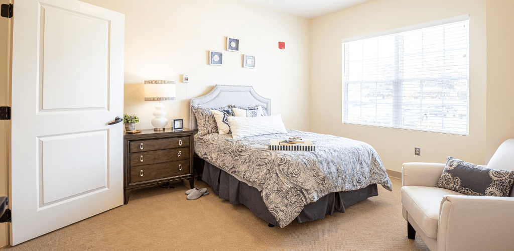 A cozy bedroom with a neatly made bed and stylish decor.