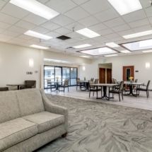 A modern lounge area with comfortable seating, tables, and bright lighting.