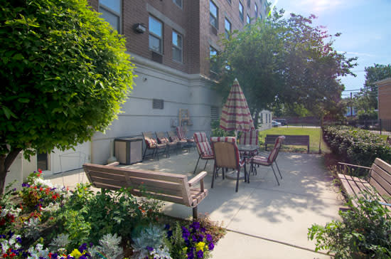A cozy outdoor patio area with seating and vibrant flowers.