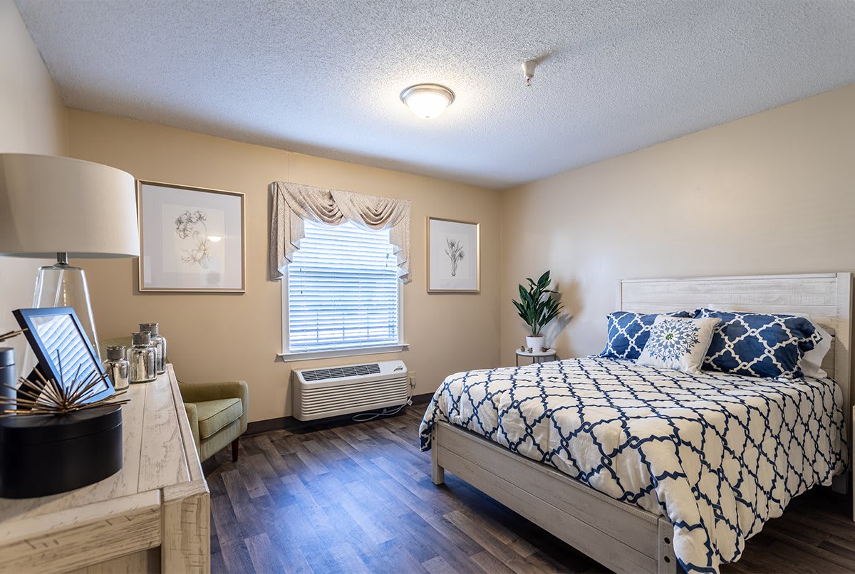 A cozy bedroom with a patterned bedspread and elegant decor.