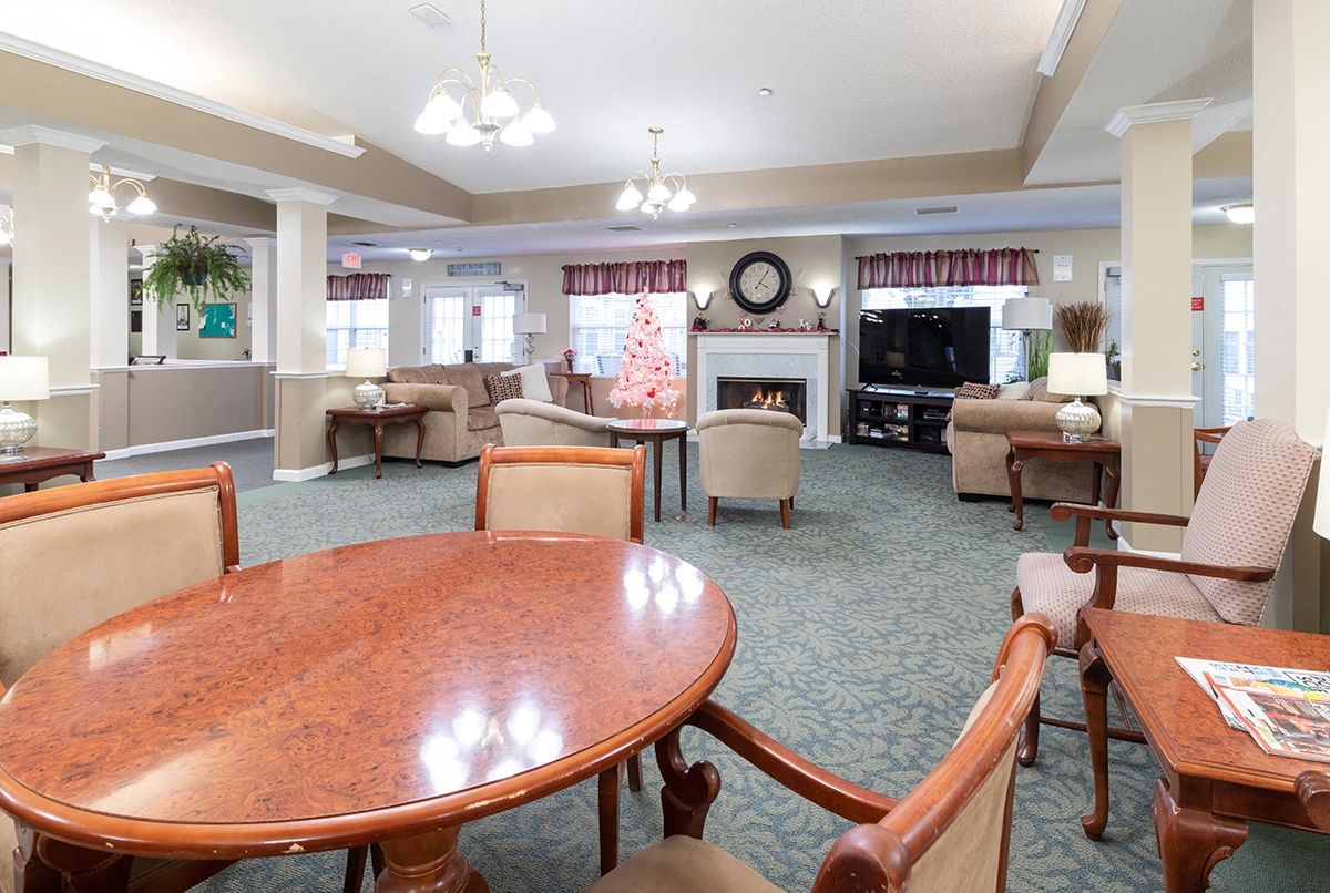 A spacious living room with a seating area, fireplace, and television.