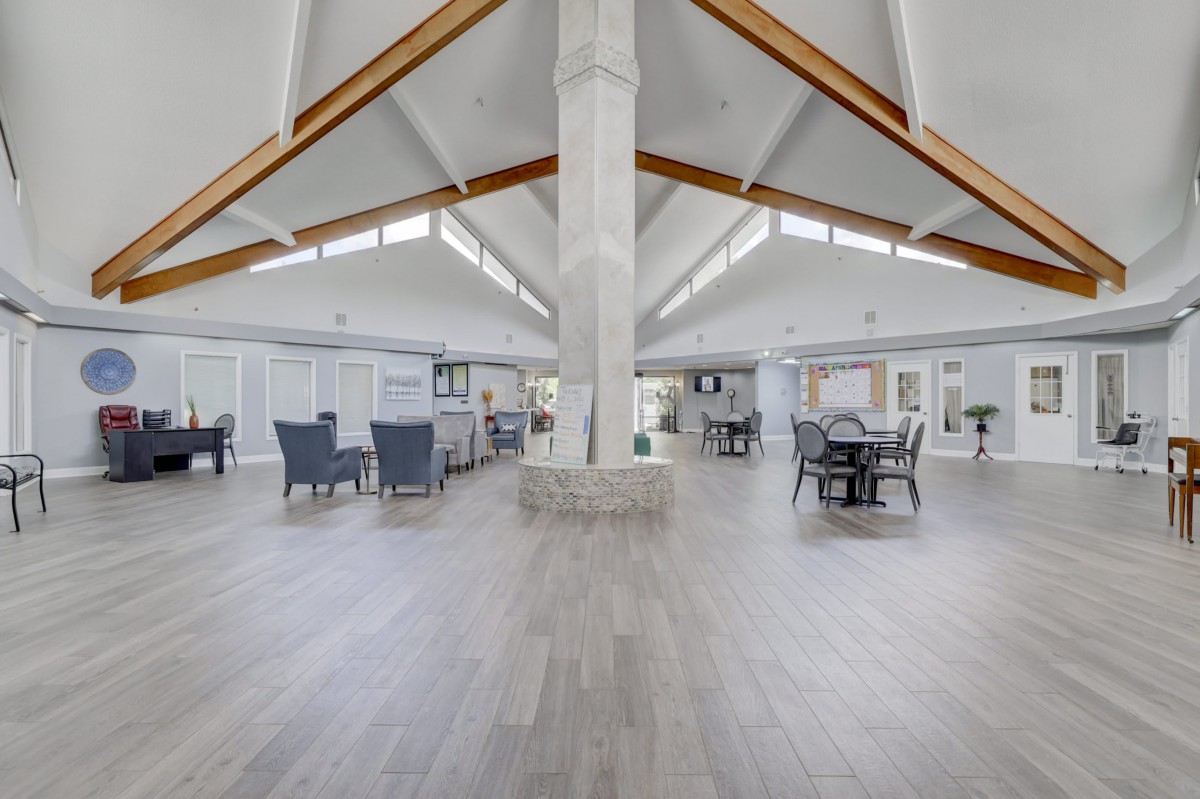 A spacious and modern interior with high ceilings and ample natural light, featuring an open layout with various seating arrangements.