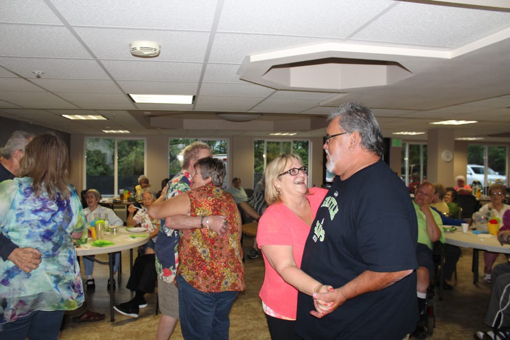 Couples dancing at an indoor social gathering.