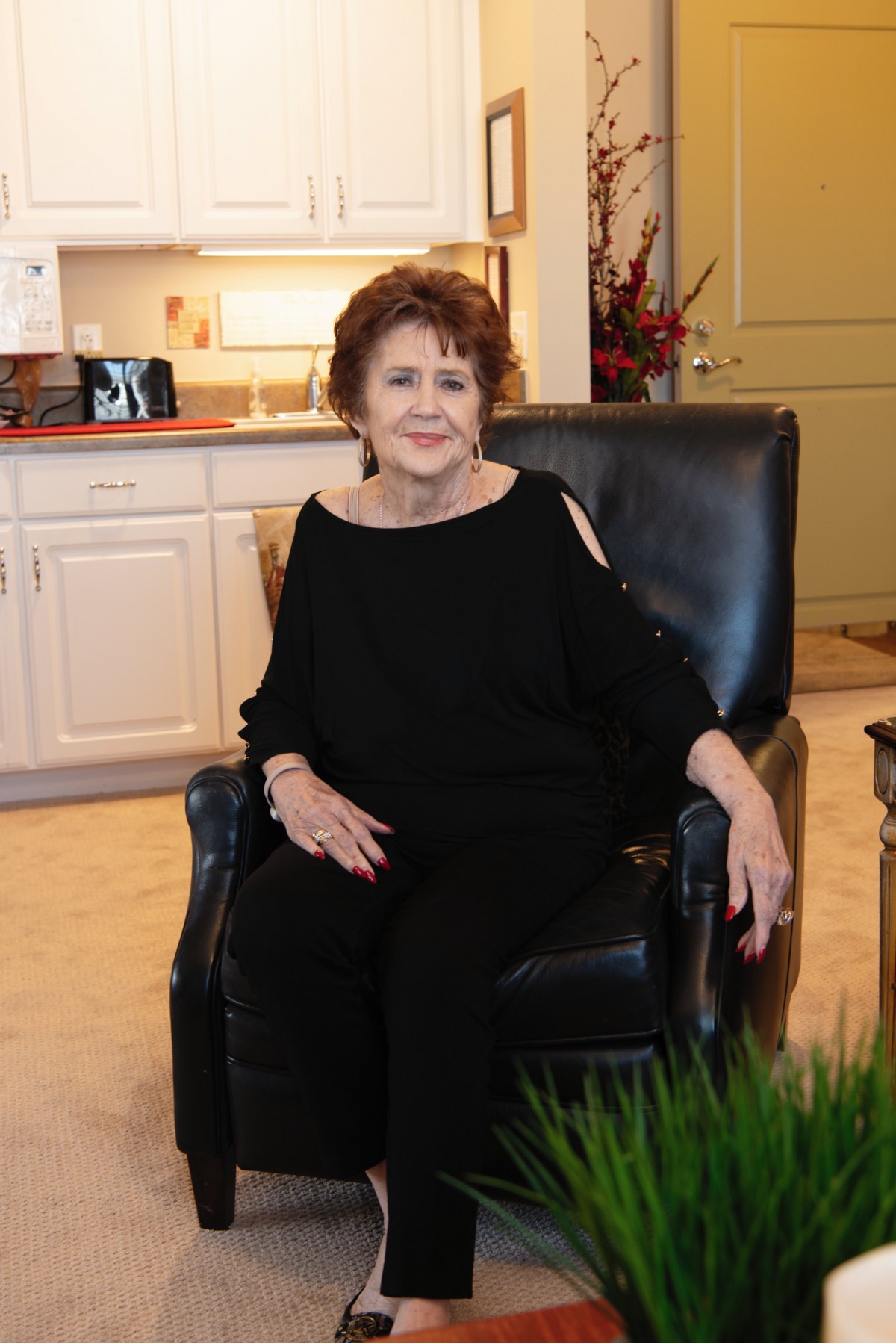 A woman sitting comfortably in a chair indoors.
