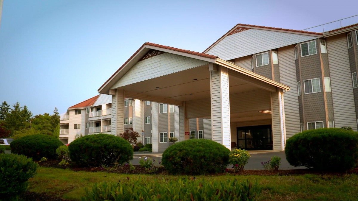 Front view of a hotel with landscaped greenery.