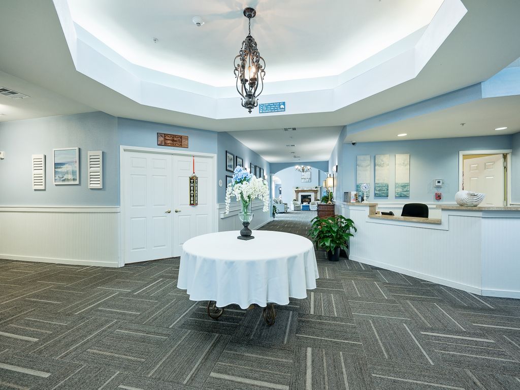 A lobby area with a round table, chandelier, and reception desk.