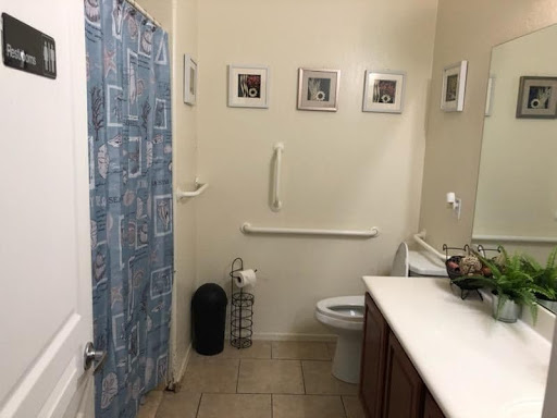 A view of a clean and organized bathroom featuring a shower, toilet, and decorative elements.