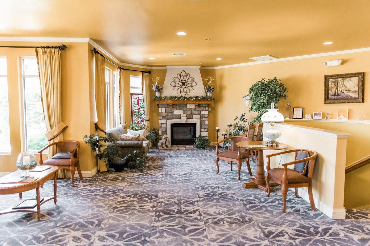 A cozy living room with a fireplace, seating area, and elegant decor.