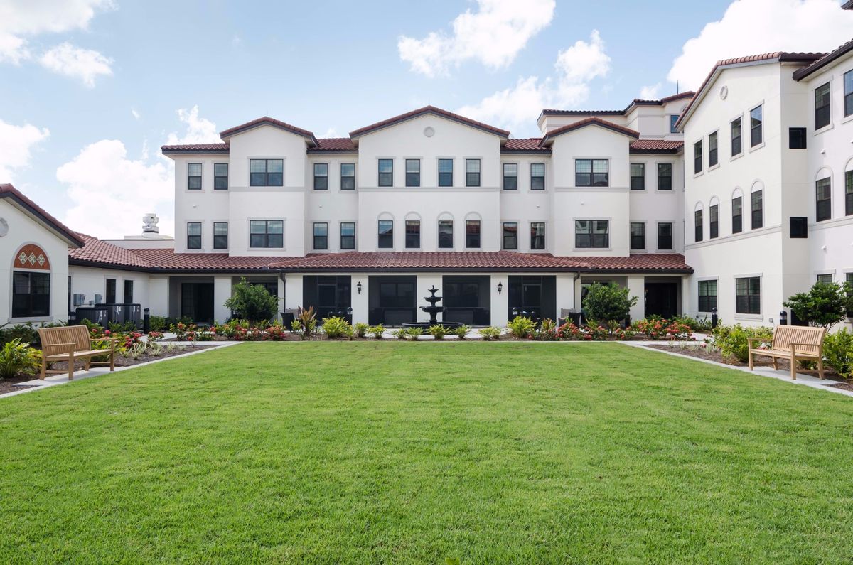 A residential building with a well-maintained lawn and clear skies.