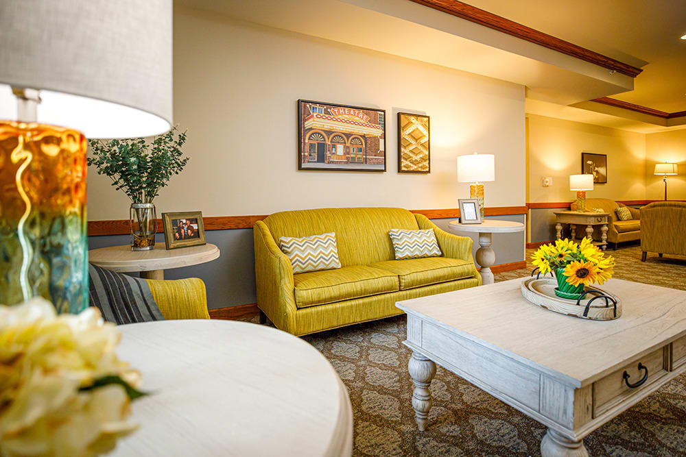 A cozy living room featuring a yellow couch with modern decor elements and warm lighting.