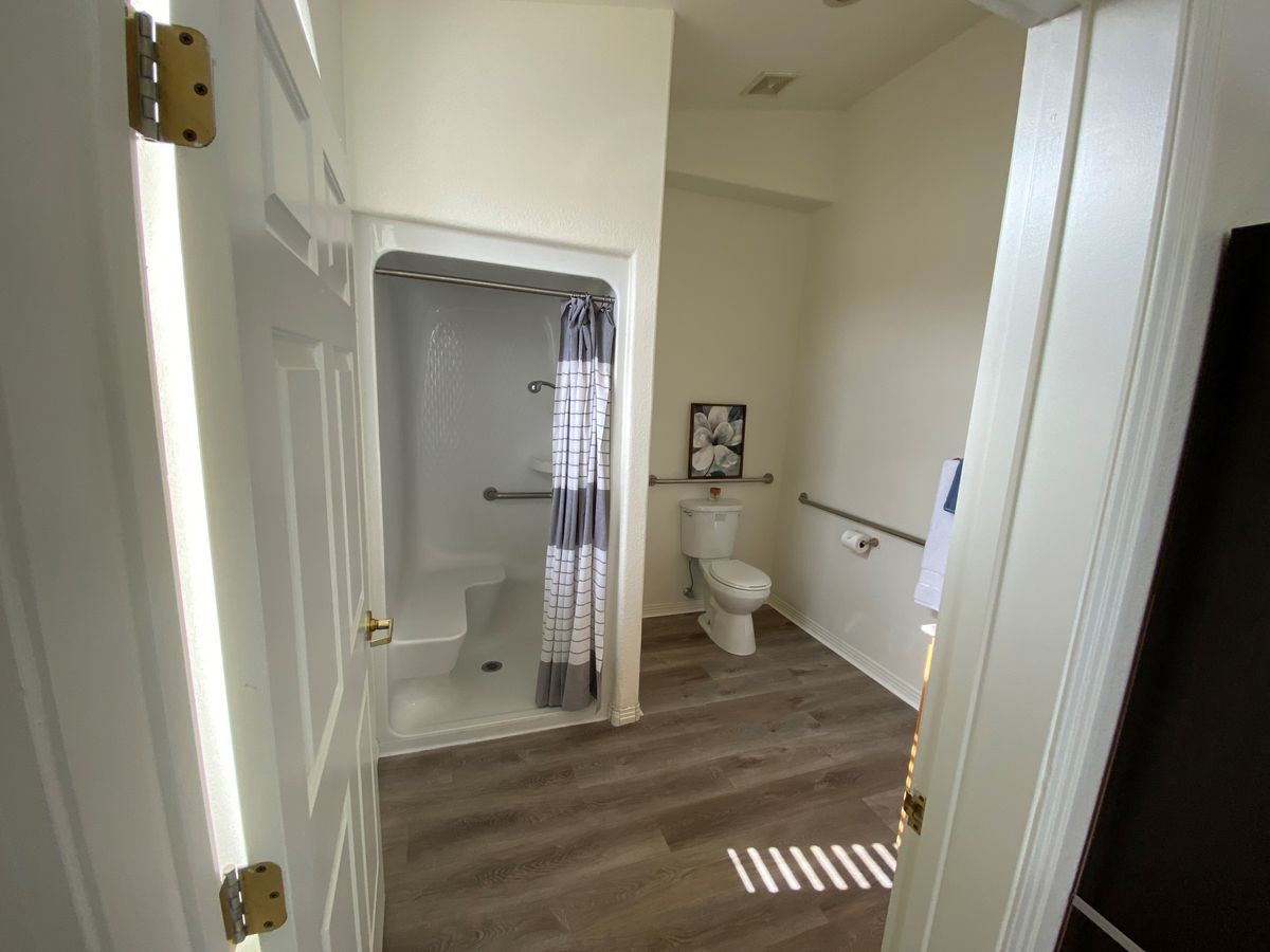 A clean and modern bathroom featuring a shower with a curtain and a toilet.