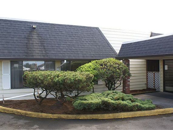 A suburban house with well-maintained landscaping and a sloped roof.