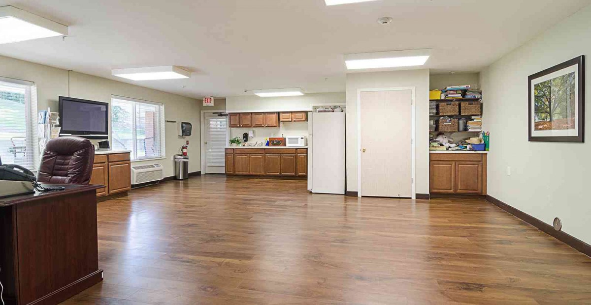 A spacious and modern kitchen interior with wooden flooring and bright lighting.