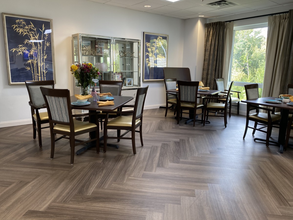 A modern dining area with wooden flooring and comfortable seating.