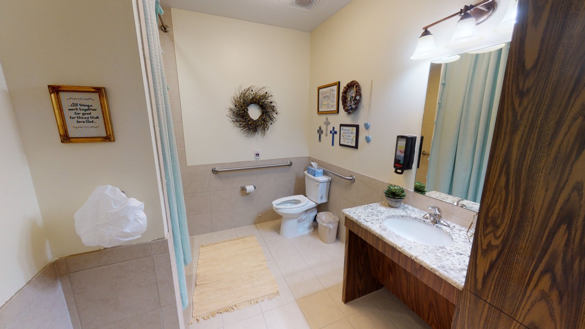 A clean and modern bathroom with decorative elements, featuring a sink, toilet, and mirror.