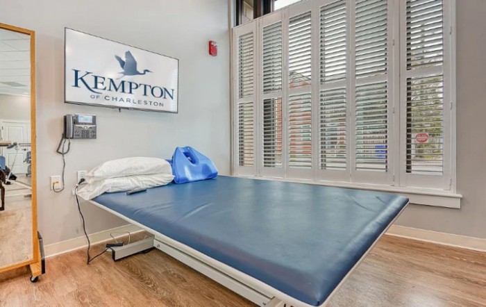 A physical therapy room with a treatment bed and equipment.