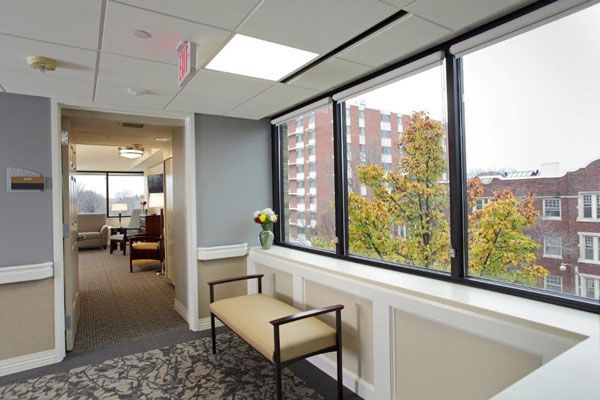 A modern waiting area with a bench and large windows offering natural light.