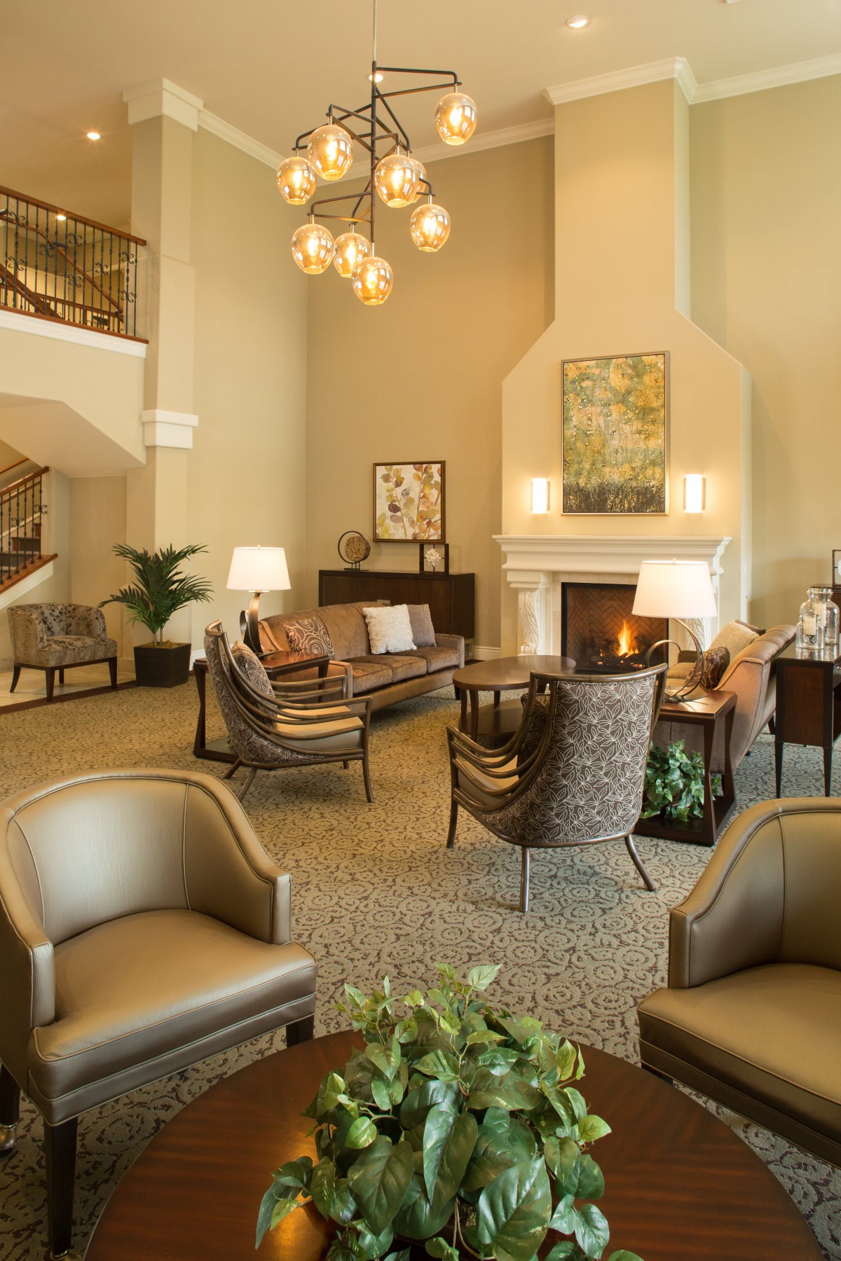A cozy hotel lobby featuring comfortable seating, a warm fireplace, and elegant decor.