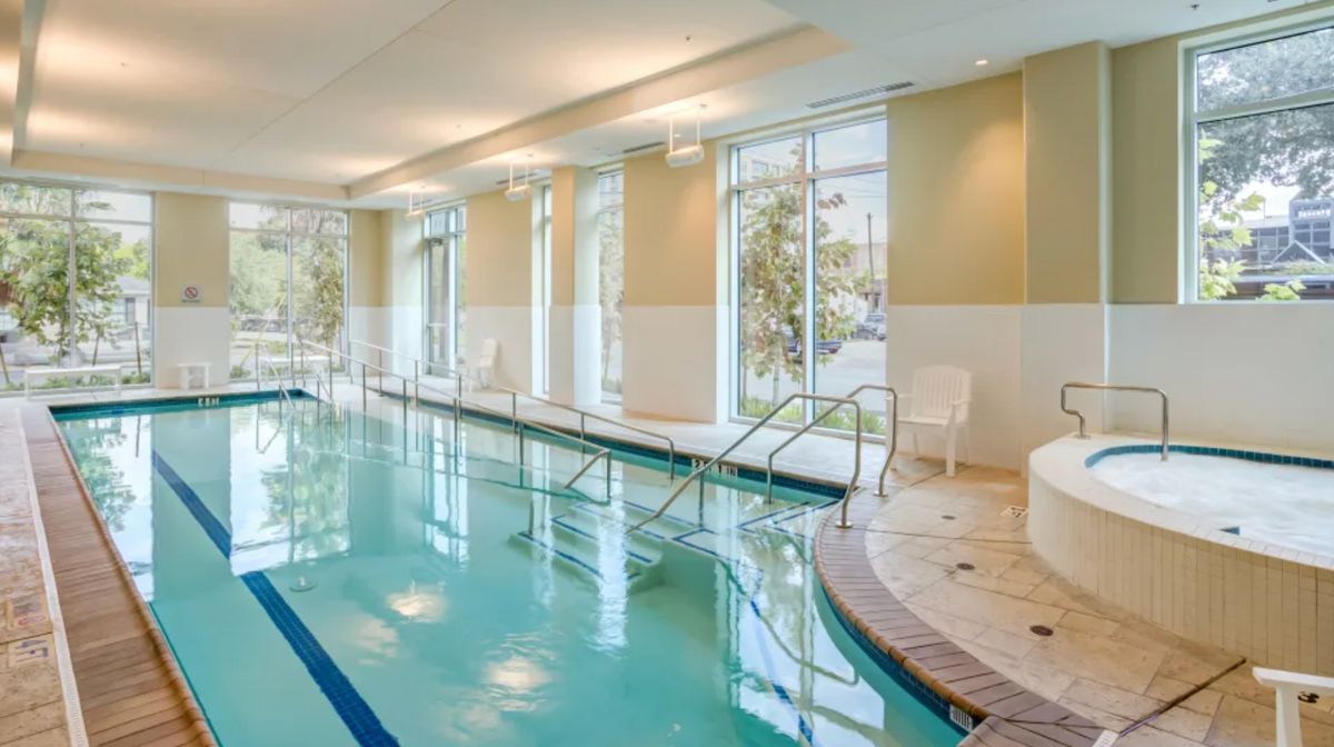 A serene indoor swimming pool with large windows and a tranquil atmosphere.