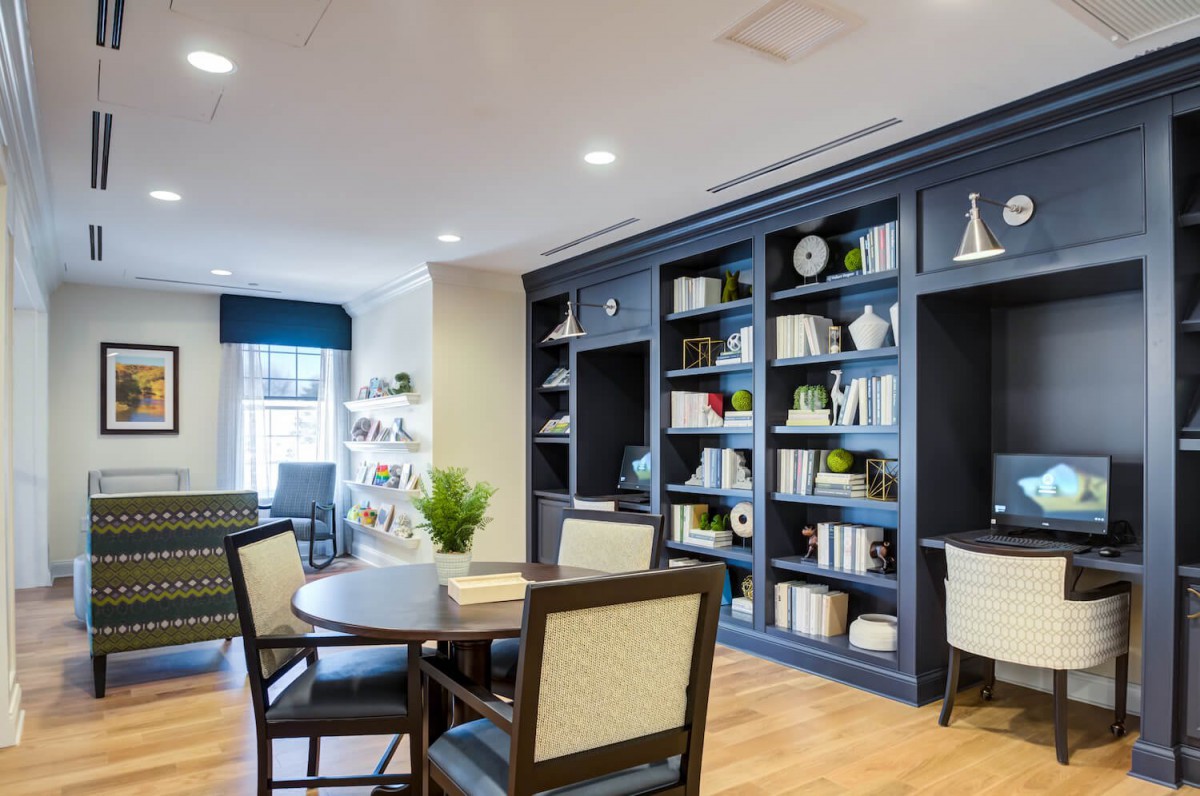 A cozy reading area with a large bookshelf and comfortable seating.