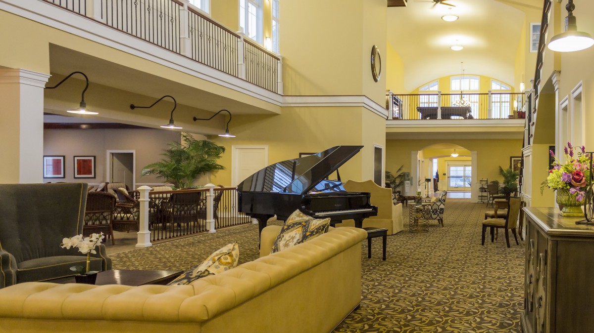 A spacious lobby with a grand piano and comfortable seating.