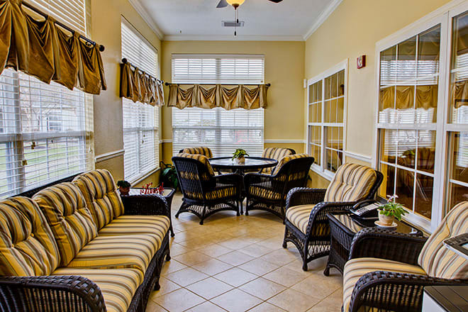 A sunlit living room with comfortable seating and large windows.
