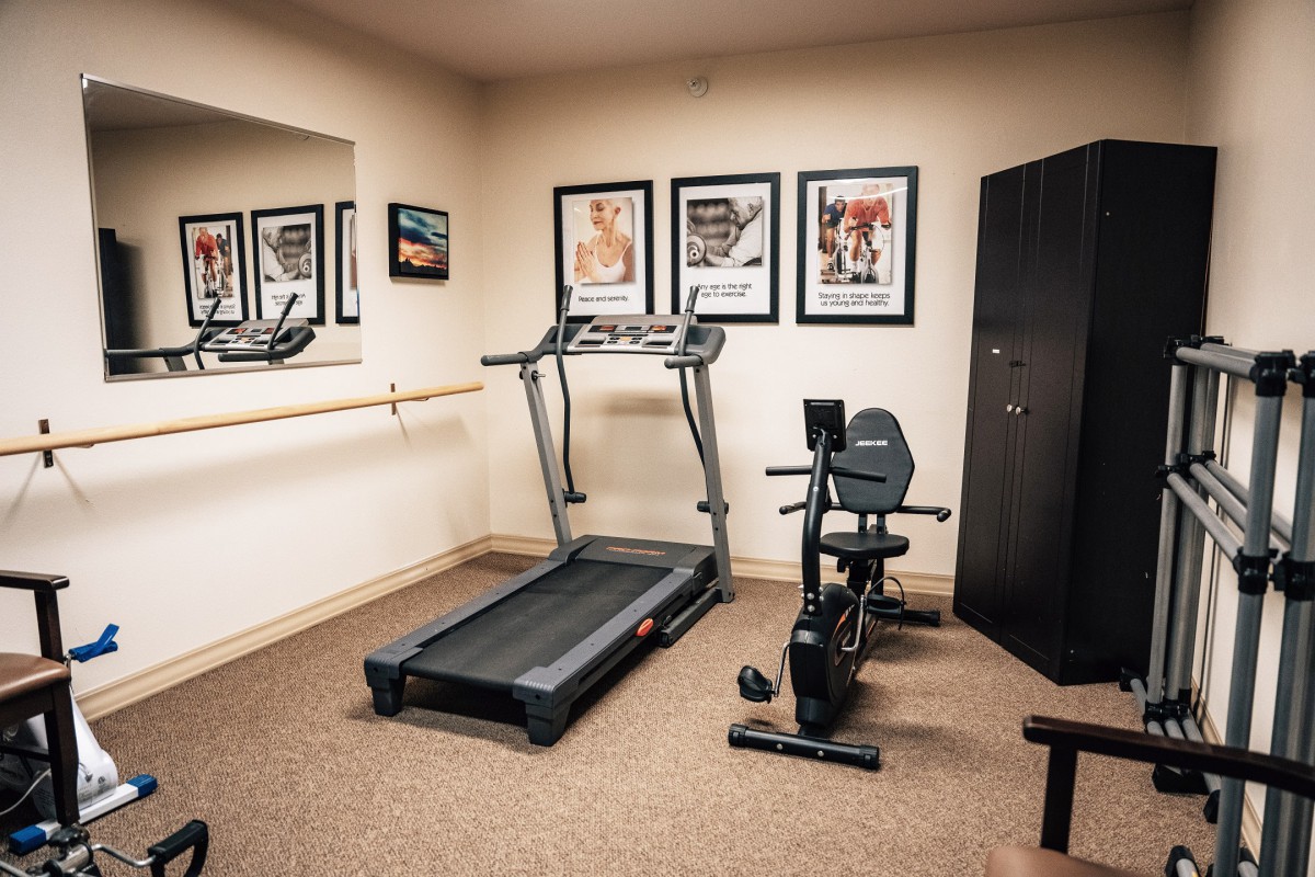 A small fitness room featuring a treadmill and stationary bike.