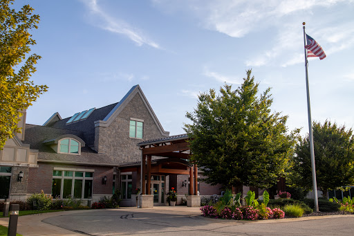 A modern hospitality building with beautiful landscaping under a clear sky.