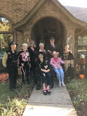 A group of friends dressed in various costumes, celebrating Halloween outdoors.