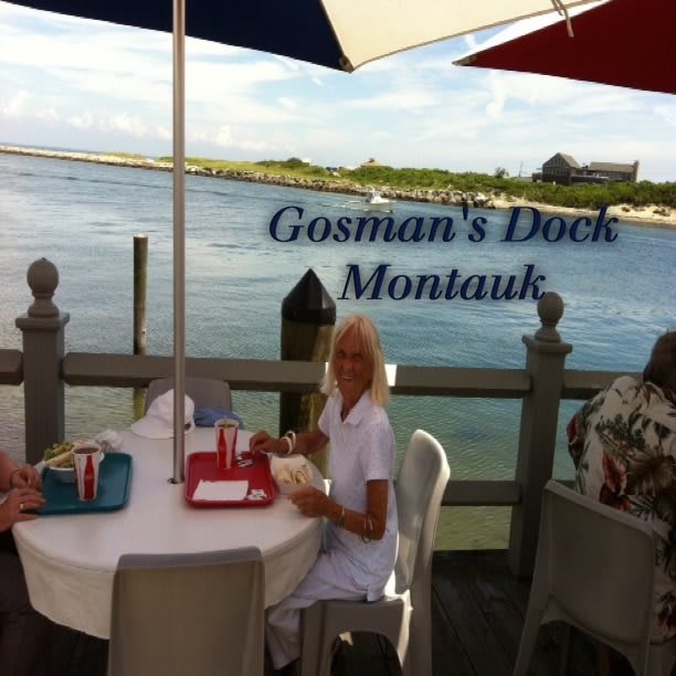 Guests enjoying a meal at Gosman's Dock in Montauk with a scenic waterfront view.