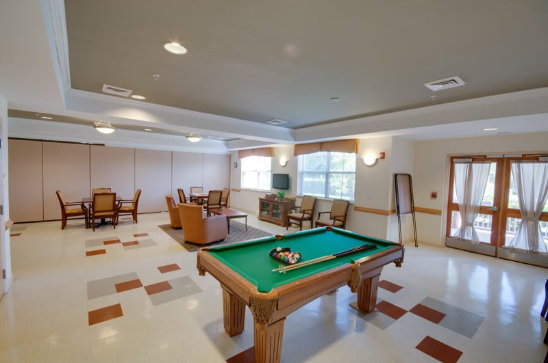 A recreation room featuring a pool table, comfortable seating, and a television.