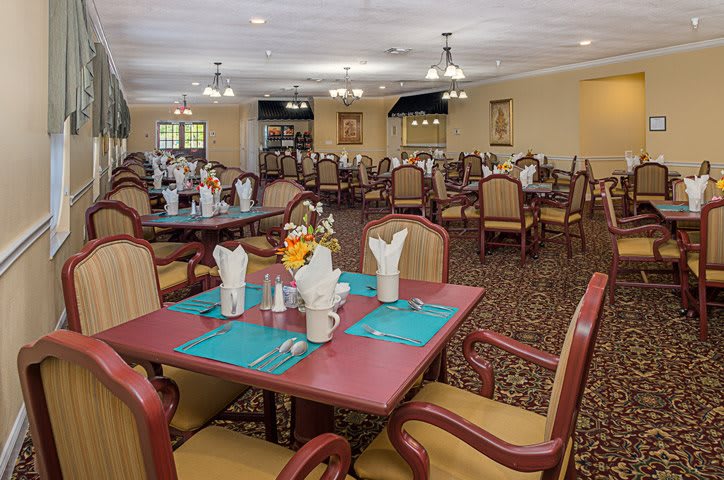 An elegant dining room with neatly set tables and comfortable chairs.