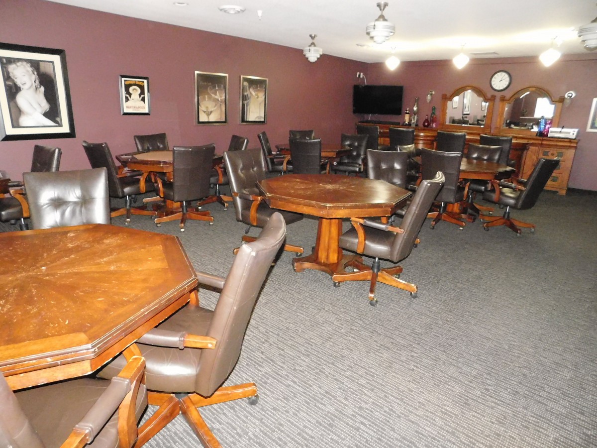 A spacious meeting room with wooden tables and chairs, featuring a comfortable setting for conferences or group gatherings.