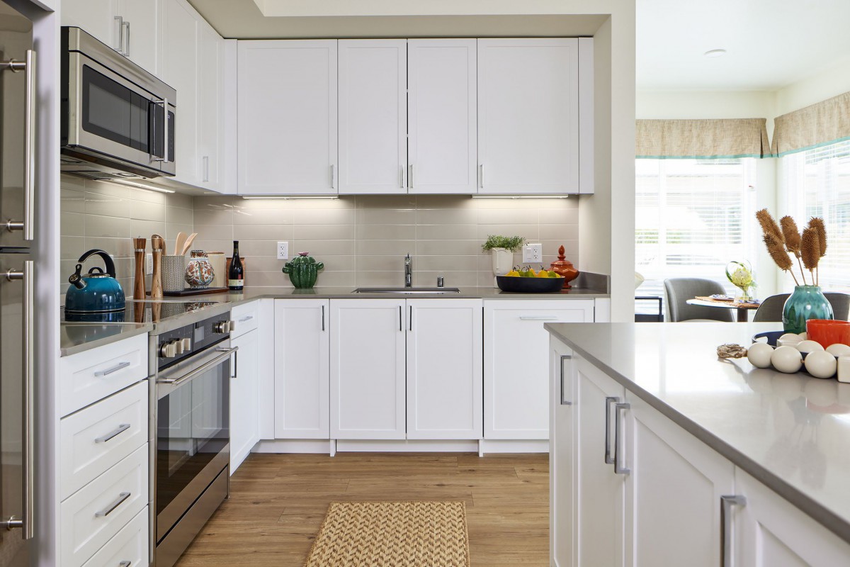 A modern kitchen with white cabinets and stainless steel appliances.