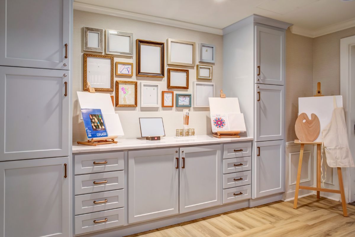 A well-organized home interior featuring cabinets and an art display with various frames.