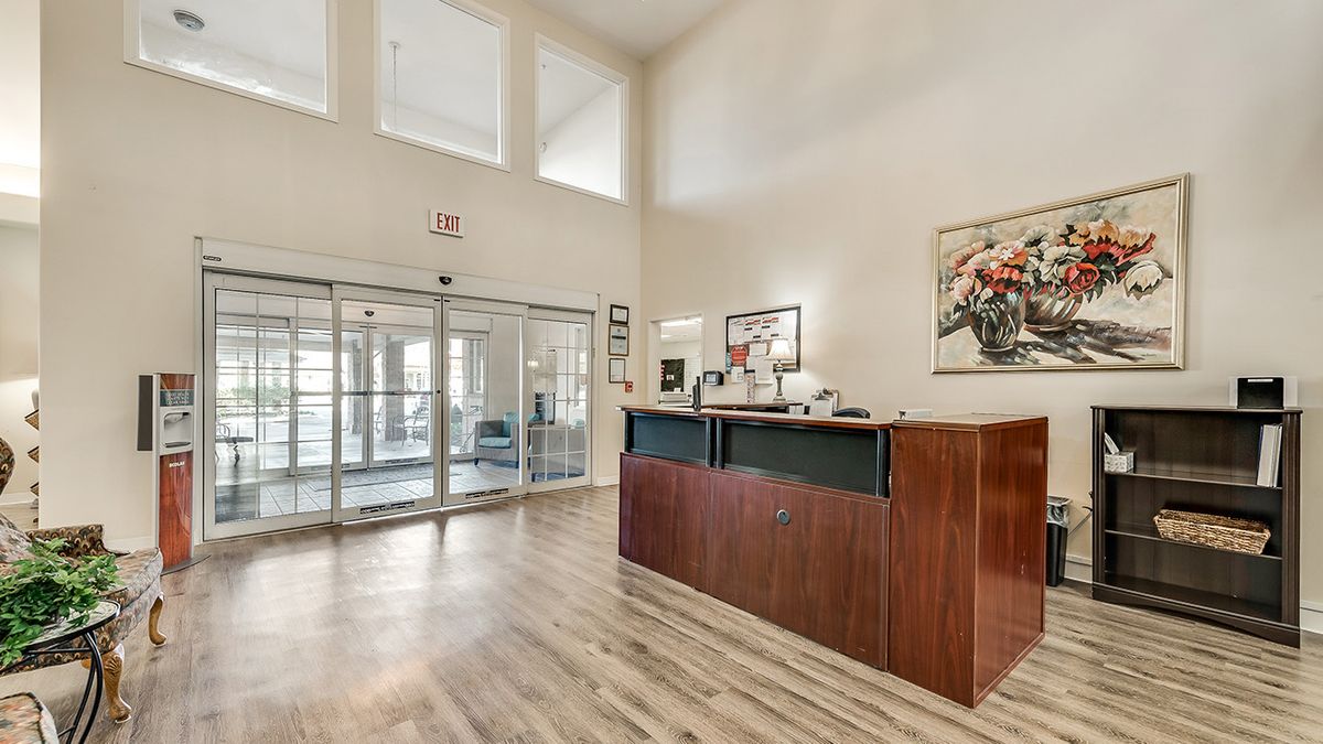 A modern reception area with a wooden desk and bright lighting.