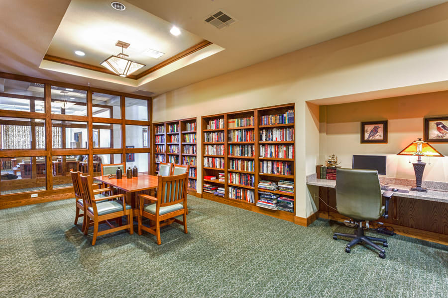 A cozy library space with bookshelves, a study table, and a computer station.