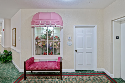 A cozy and inviting interior space featuring a stylish pink bench and a decorative window with a canopy.