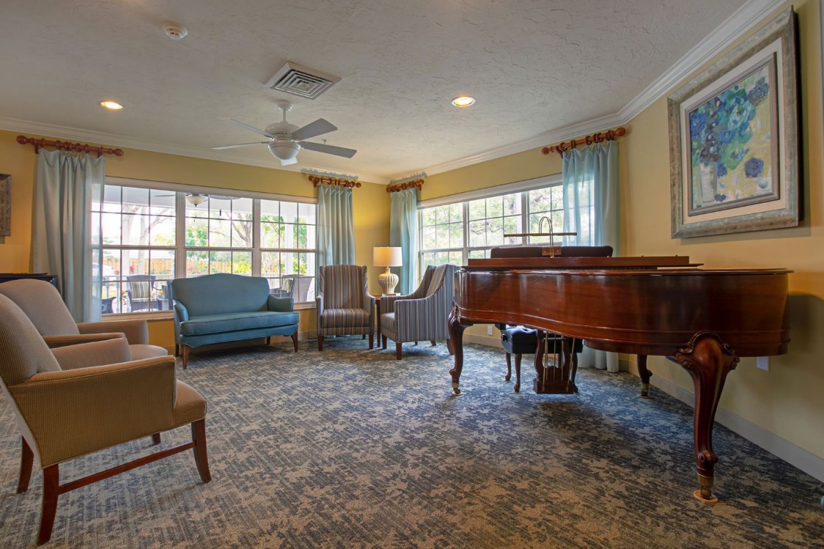 A cozy living room with a grand piano and comfortable seating.