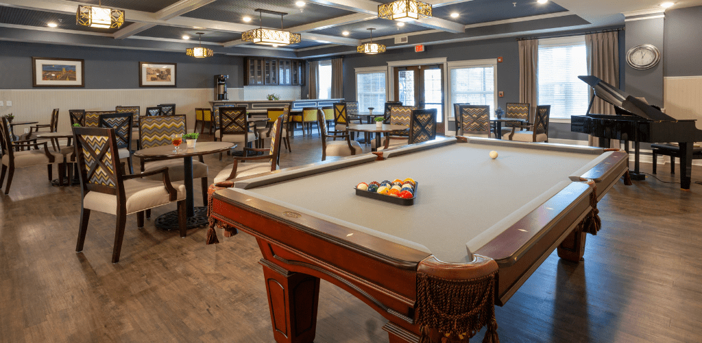 A spacious game room featuring a billiards table and a dining area.