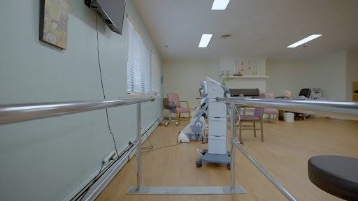A physical therapy room featuring rehabilitation equipment and a wheelchair ramp.