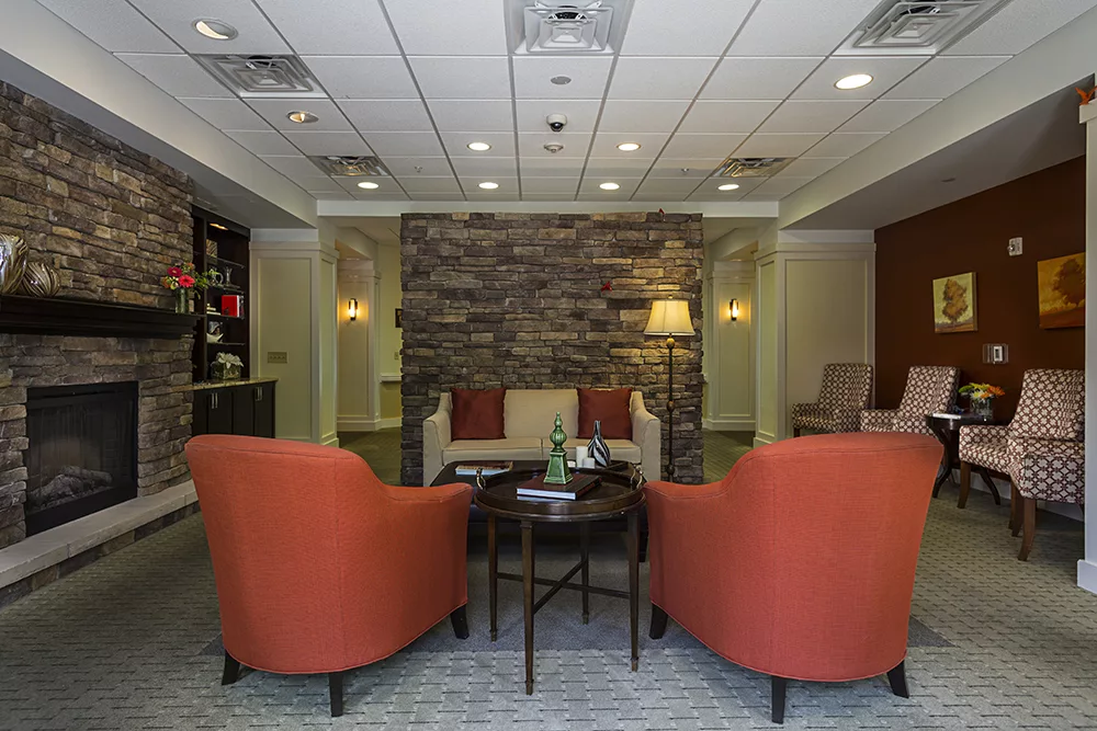 A cozy lobby seating area with comfortable chairs and a stone wall backdrop.